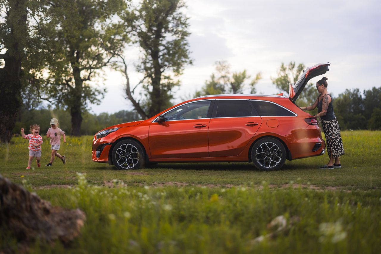 pomarańczowa Kia Ceed kombi z rodziną