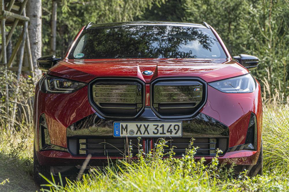 czerwone BMW X3 M50 xDrive stojące w trawie